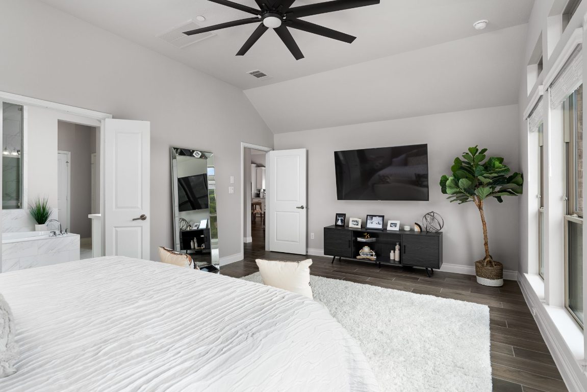 6105 Fadden Road Austin, TX 78738 - Photo 19 of 40 a bedroom with a bed a flat screen tv and a chandelier