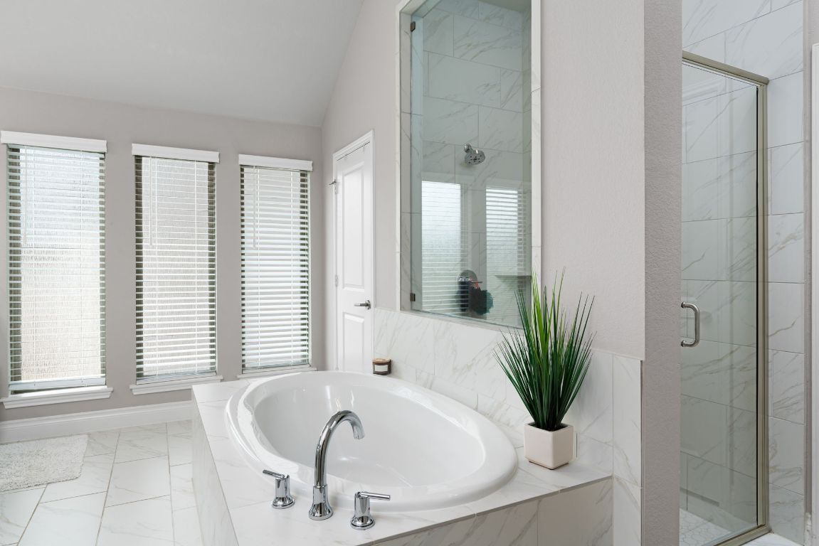 6105 Fadden Road Austin, TX 78738 - Photo 22 of 40 a bath tub sitting in a bathroom next to a window