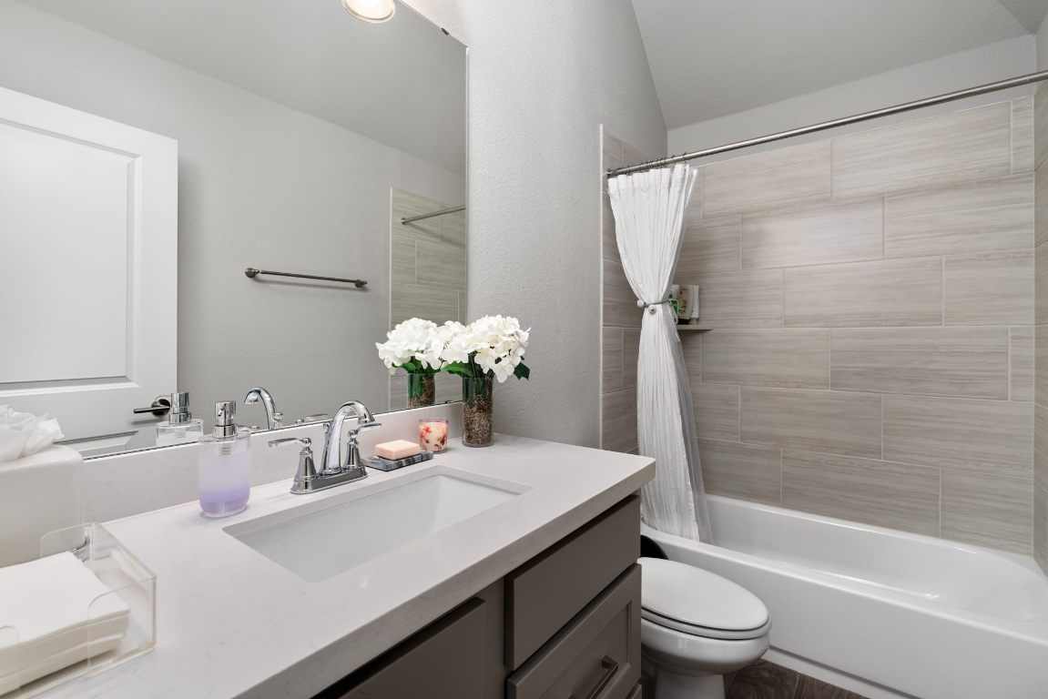 6105 Fadden Road Austin, TX 78738 - Photo 27 of 40 a bathroom with a granite countertop sink a toilet and shower