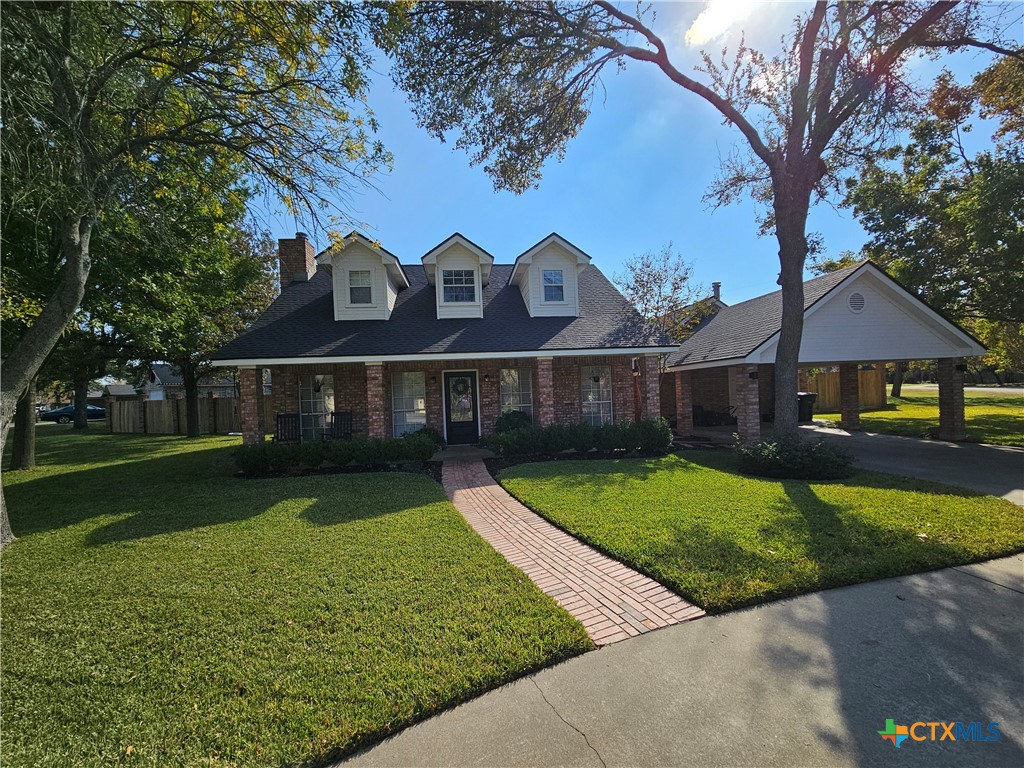 a front view of a house with a garden and yard