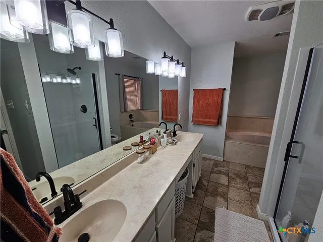 a bathroom with a sink double vanity granite and a mirror