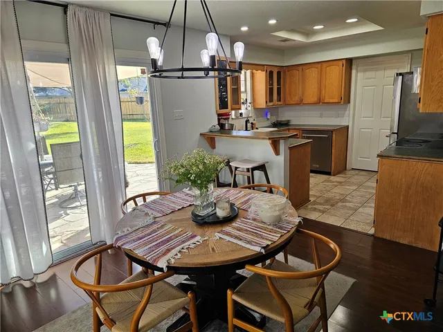 a kitchen with a table chairs refrigerator and microwave