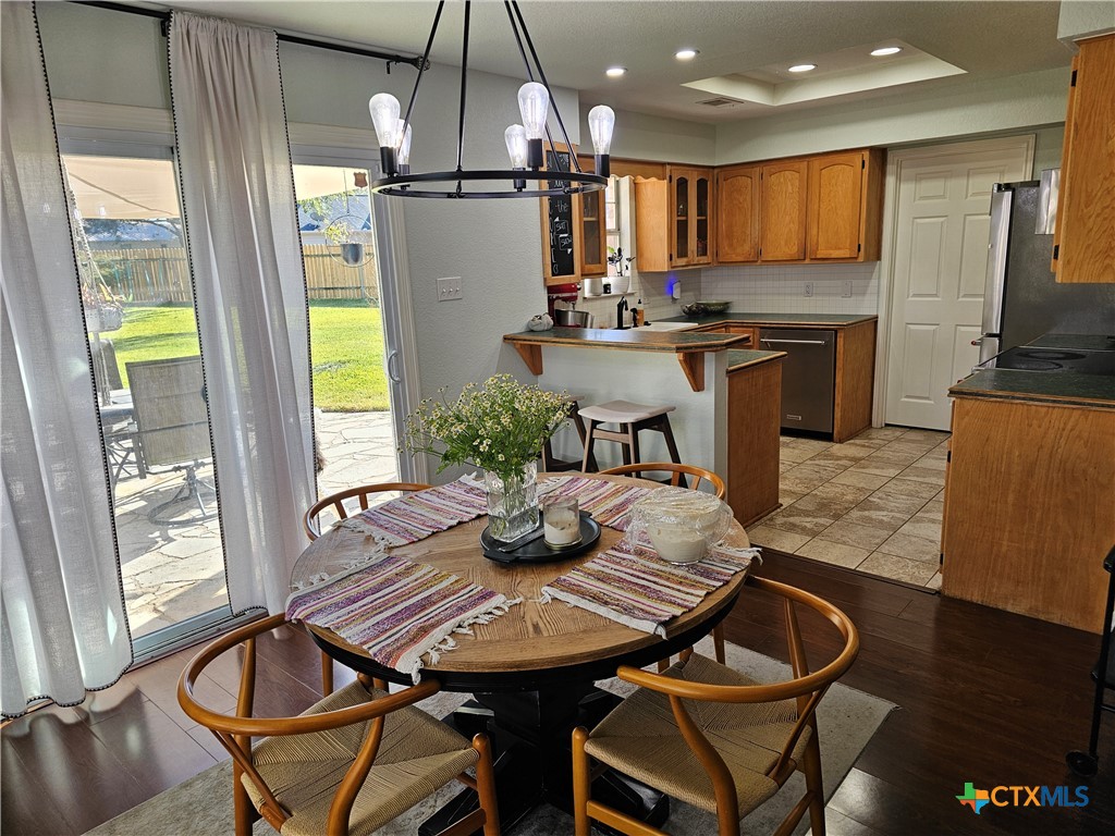 963 Benchmark Trail Belton, TX 76513 - Photo 5 of 6 a kitchen with a table chairs refrigerator and microwave