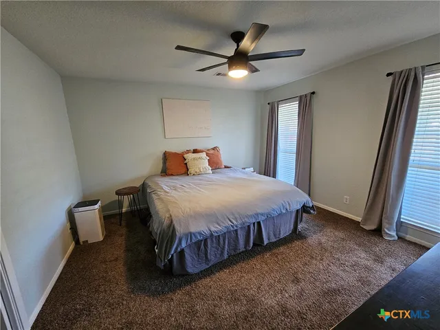 a bed sitting in a spacious bedroom next to a window