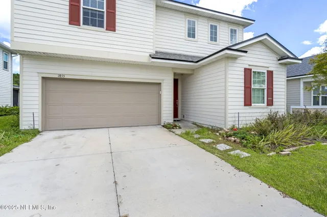 a front view of a house with a yard and garage