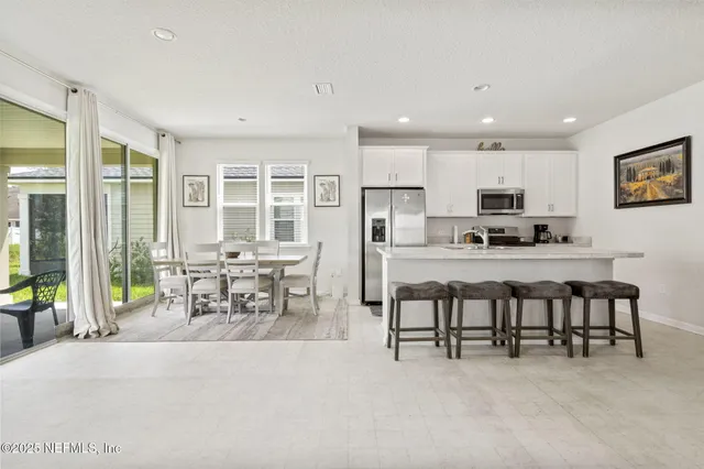 a kitchen with stainless steel appliances kitchen island granite top and refrigerator