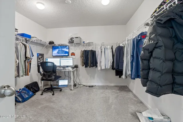 a view of walk in closet with clothes and shoes