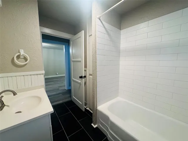 a bathroom with a tub a sink and a shower