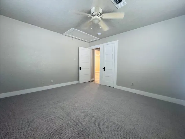en empty room with windows and ceiling fan