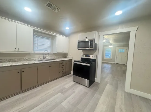 a kitchen with stainless steel appliances granite countertop a stove a sink and a refrigerator