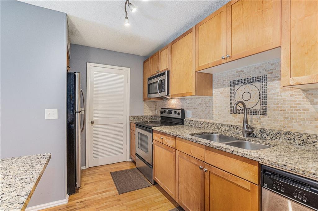 2657 Lenox Road Northeast, Unit C38 Atlanta, GA 30324 - Photo 9 of 20 a kitchen with stainless steel appliances granite countertop a sink stove and refrigerator