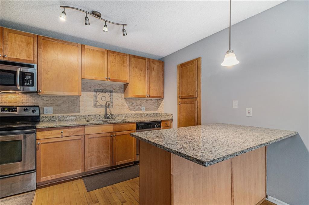2657 Lenox Road Northeast, Unit C38 Atlanta, GA 30324 - Photo 10 of 20 a kitchen with granite countertop kitchen island a sink appliances and cabinets