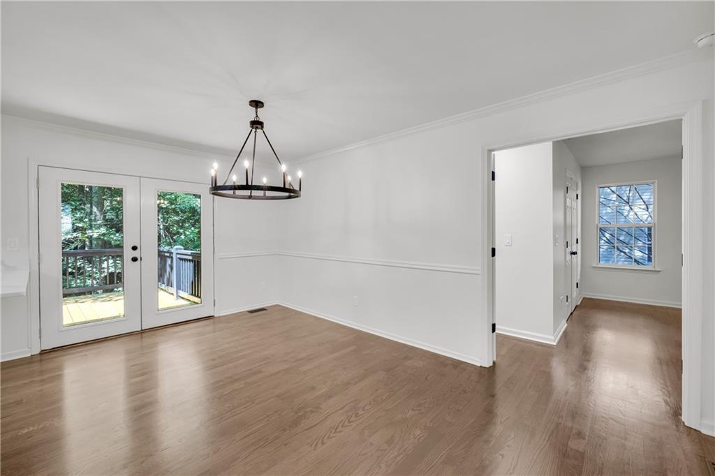 2941 Lake Hollow Road Gainesville, GA 30501 - Photo 19 of 53 an empty room with wooden floor chandelier and windows