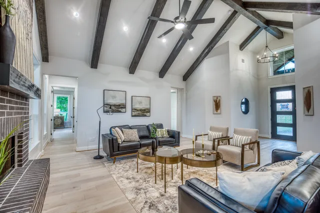 a living room with fireplace furniture and a rug