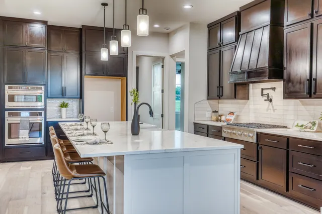 a kitchen with granite countertop a sink stainless steel appliances and cabinets