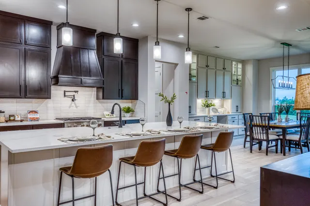 a kitchen with kitchen island granite countertop a sink a center island stainless steel appliances and cabinets