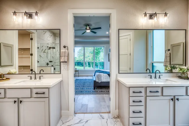 a en suite bathroom with a sink a large mirror and a shower