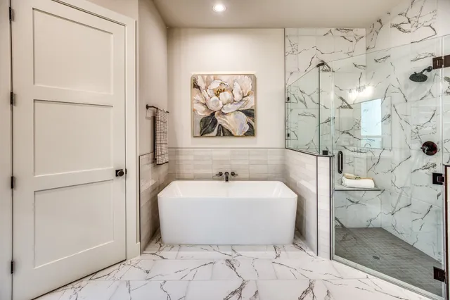 a white bath tub sitting next to a white toilet and a shower