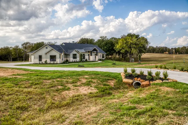 a view of a house with backyard and sitting area
