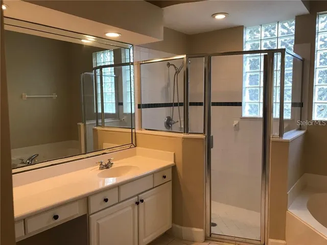 a bathroom with a shower sink and mirror