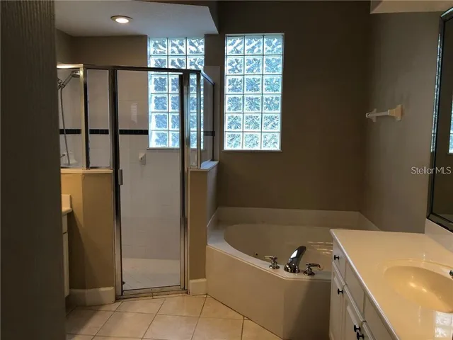 a bathroom with a tub a sink and a shower