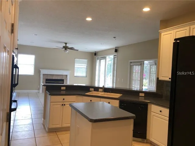 a kitchen with granite countertop a sink a counter top space appliances and cabinets