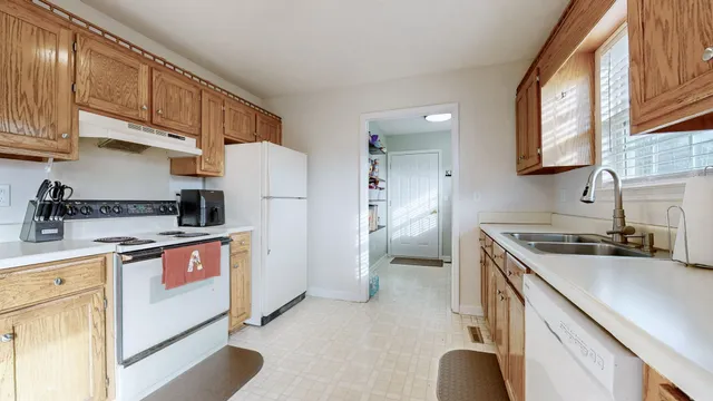 a kitchen with stainless steel appliances granite countertop a sink stove refrigerator a oven with white cabinets