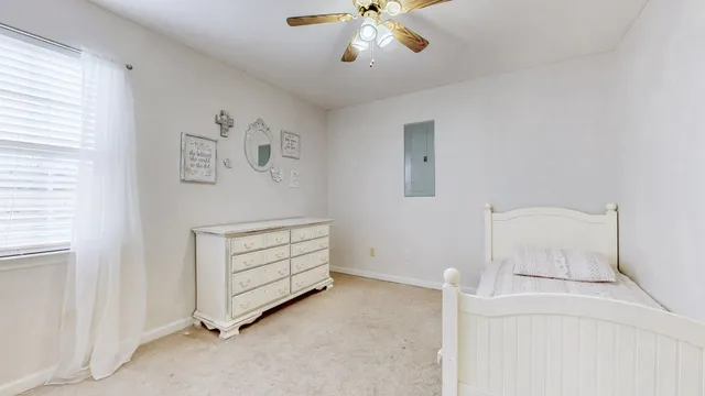 a view of an empty room with a window and a ceiling fan
