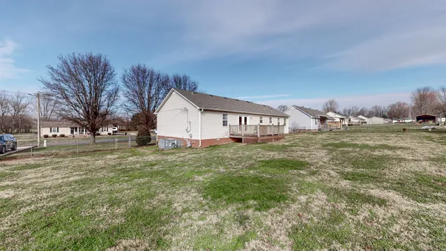 a view of a house with backyard and trees