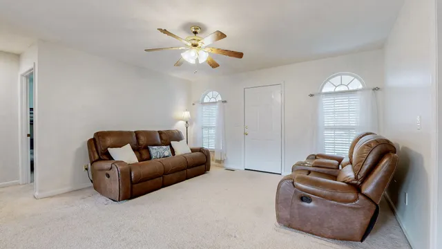 a living room with furniture a chandelier and a window