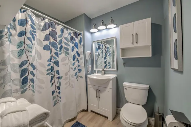 a bathroom with a toilet sink and shower curtain