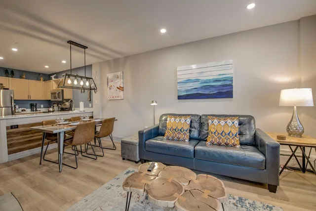 a living room with furniture and a view of kitchen