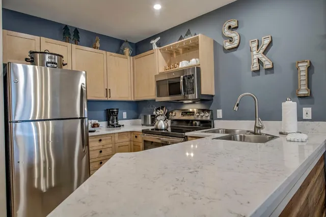 a kitchen with stainless steel appliances granite countertop a refrigerator sink and microwave