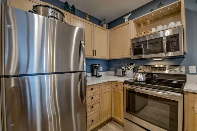 a kitchen with stainless steel appliances a refrigerator sink and microwave