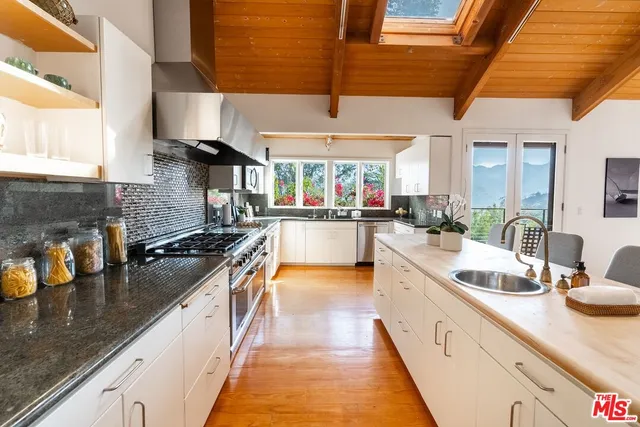 a large kitchen with stainless steel appliances granite countertop a sink and stove