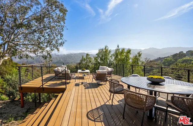 a view of a balcony with chairs and wooden floor
