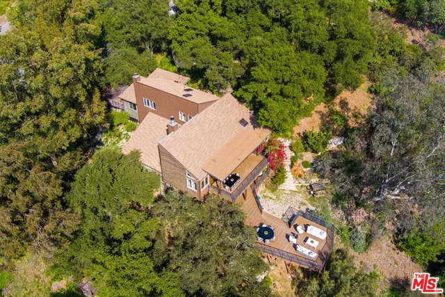 an aerial view of a house with a yard and parking