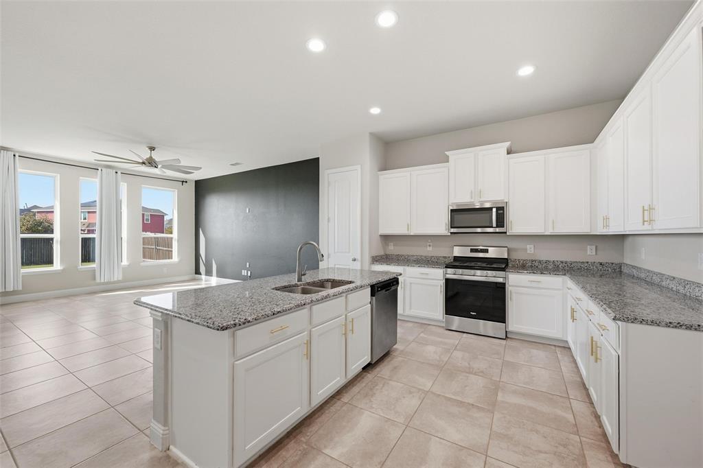 2013 Historic District Aubrey, TX 76227 - Photo 6 of 25 a kitchen with stainless steel appliances granite countertop a stove sink and cabinets