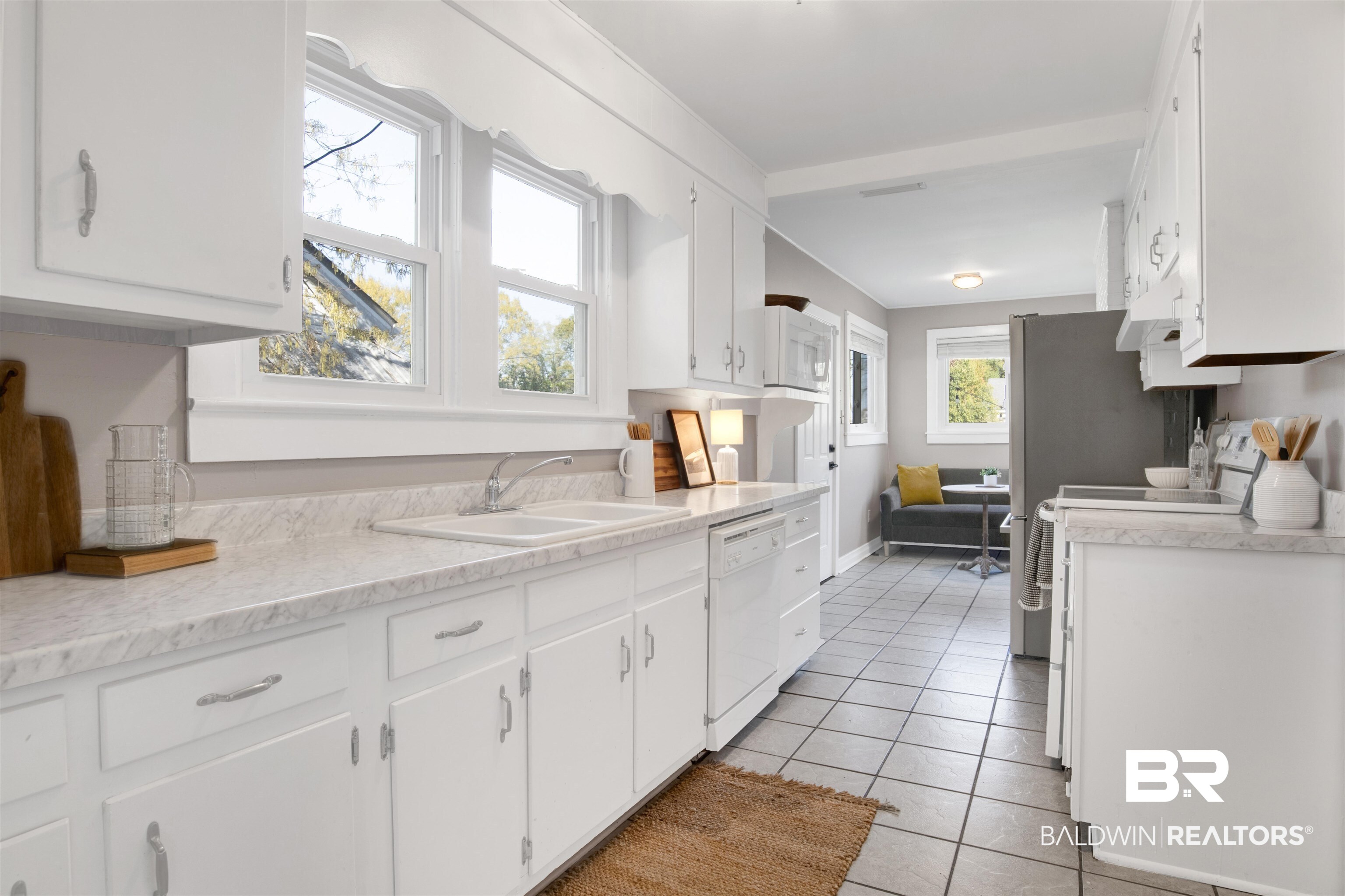 160 Emogene Place Mobile, AL 36606 - Photo 9 of 32 Kitchen with light countertops, white cabinetry, white appliances, and light tile patterned flooring