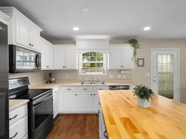 a kitchen with granite countertop cabinets stainless steel appliances and window