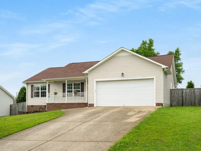 a front view of a house with a yard and trees