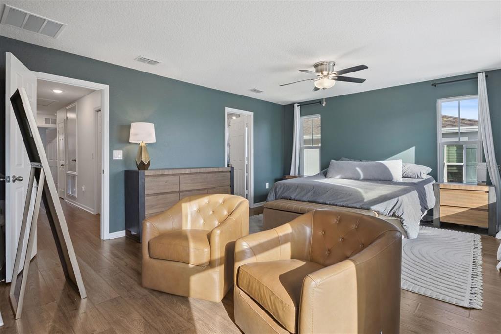 15448 Blackbead Street Winter Garden, FL 34787 - Photo 12 of 28 a bedroom with furniture and a chandelier