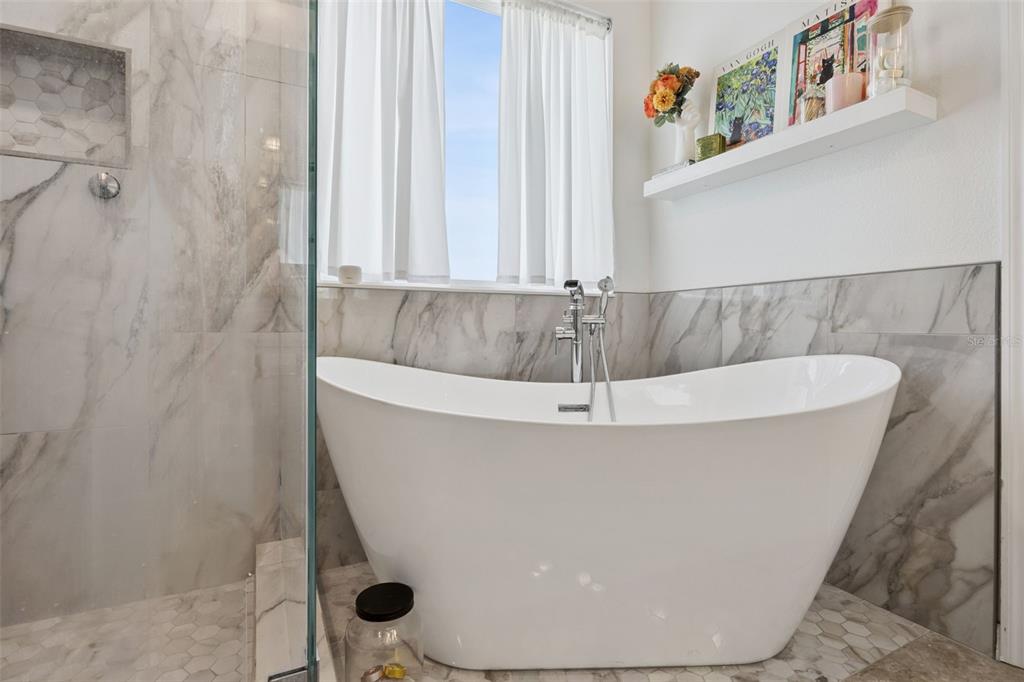 15448 Blackbead Street Winter Garden, FL 34787 - Photo 15 of 28 a white bath tub sitting in a bathroom