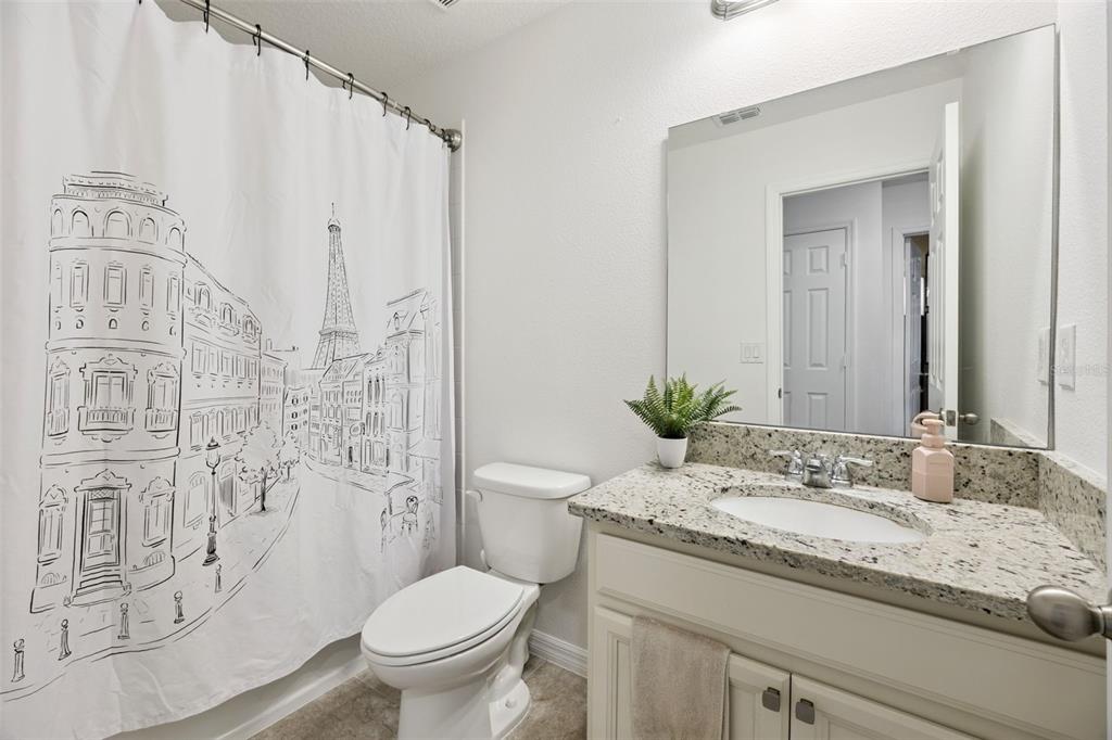 15448 Blackbead Street Winter Garden, FL 34787 - Photo 17 of 28 a bathroom with a granite countertop sink a toilet and a mirror