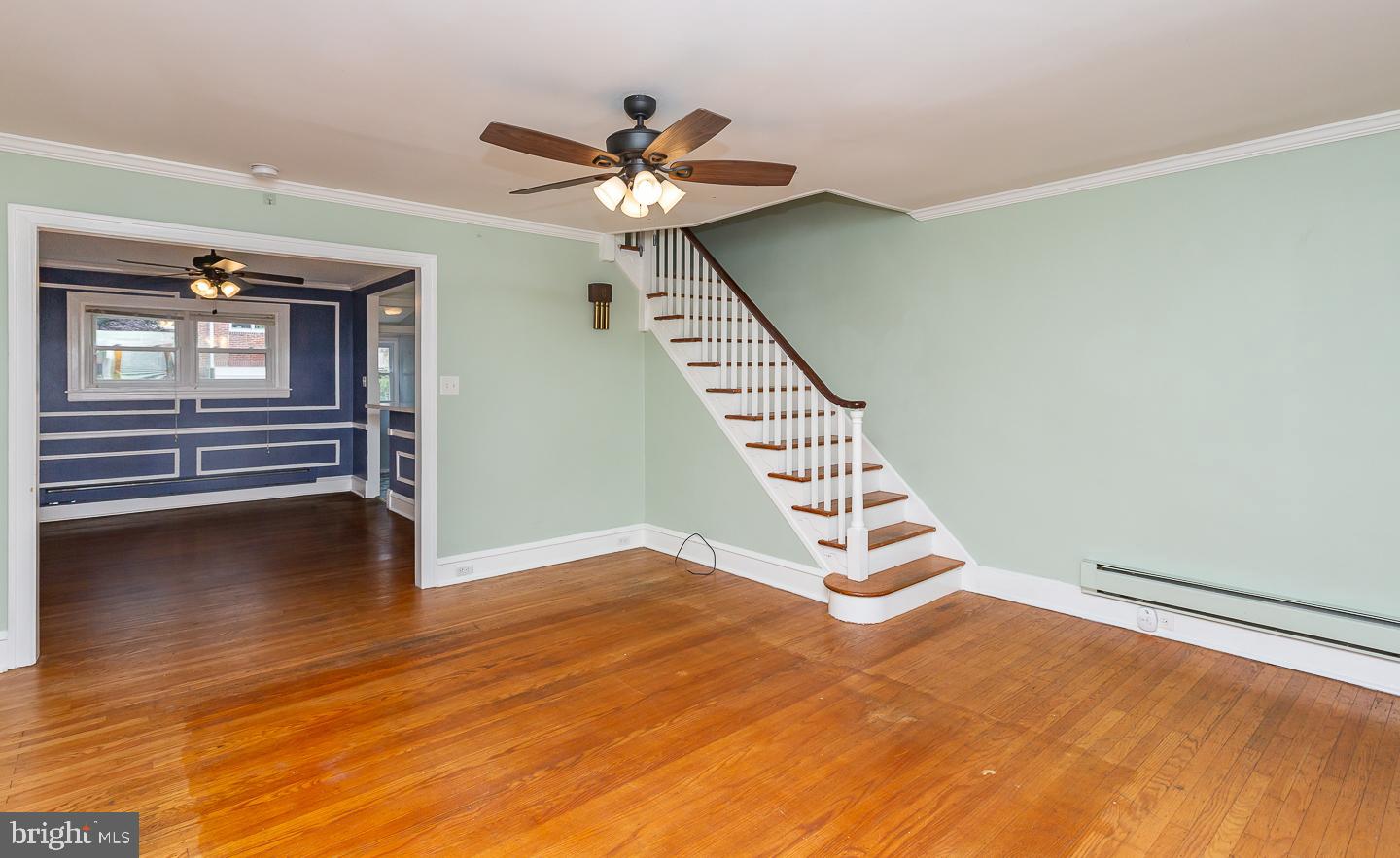 6609 Morris Park Road Philadelphia, PA 19151 - Photo 3 of 35 a view of an empty room with wooden floor stairs and a ceiling fan