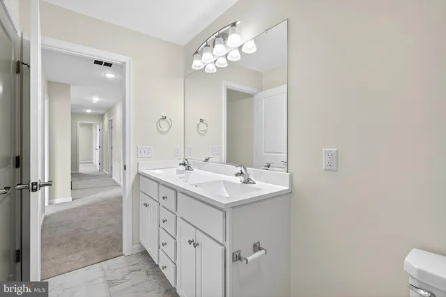 a spacious bathroom with a double vanity sink mirror and toilet