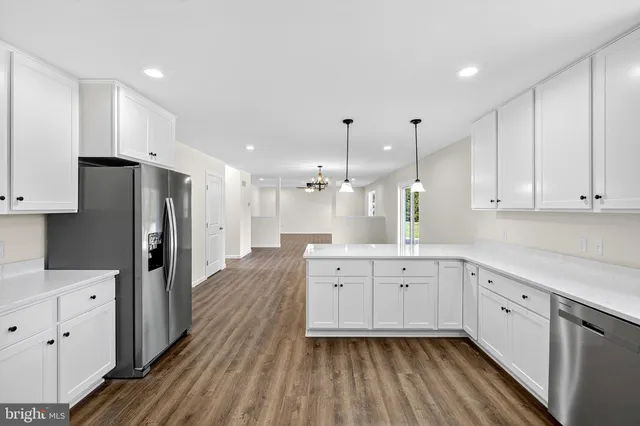 a large kitchen with cabinets wooden floor and stainless steel appliances