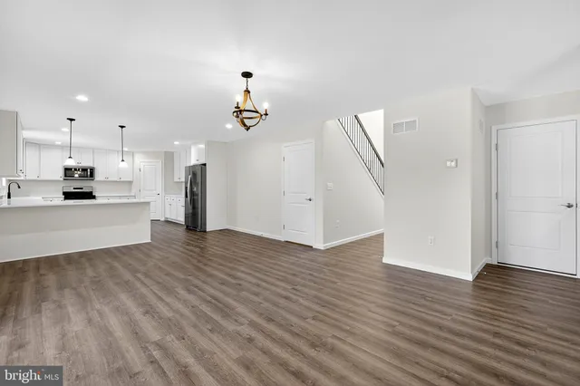 a view of a kitchen with wooden floor and electronic appliances