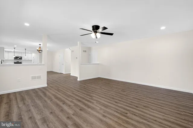a view of a kitchen with wooden floor and a ceiling fan