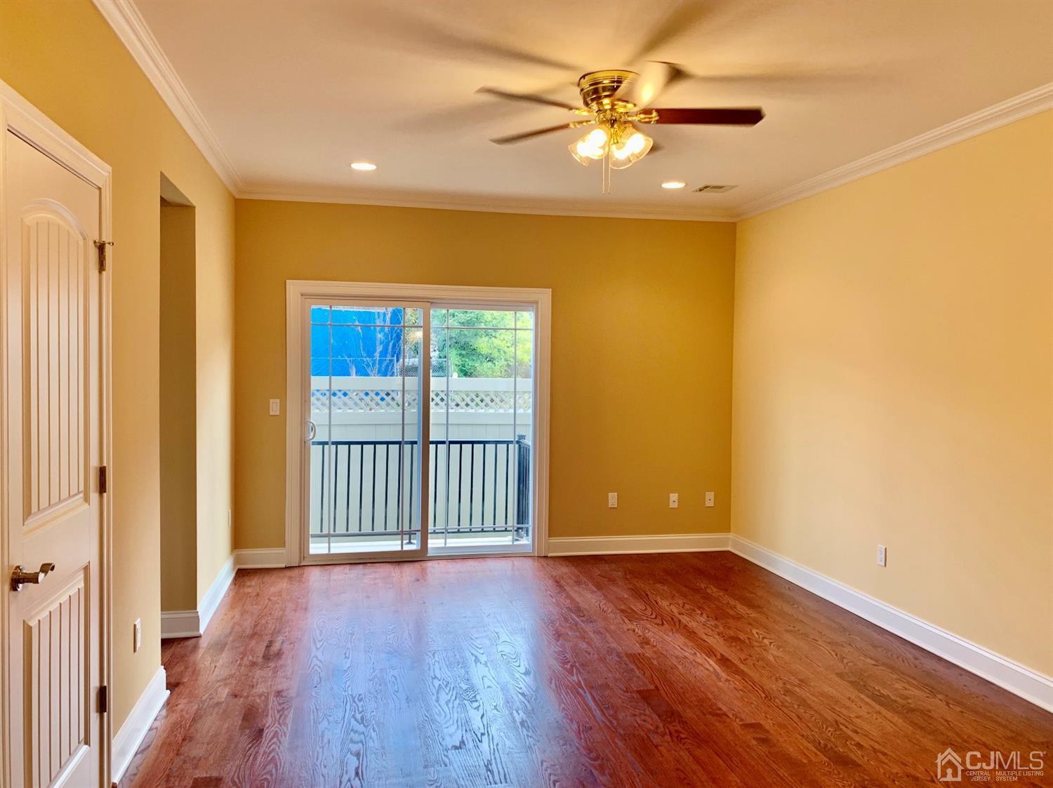 144 Harding Avenue, Unit 2 Edison, NJ 08820 - Photo 7 of 12 a view of a livingroom with wooden floor and a ceiling fan